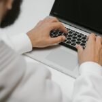 A male programmer intensely typing code on a laptop, showcasing modern technology and software development.